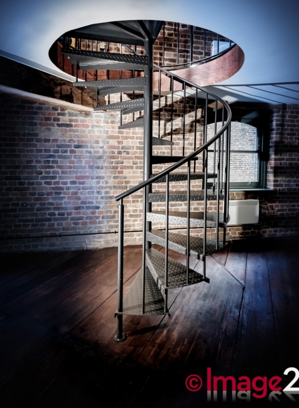 Dramatic looking spiral staircase in an industrial" look" office basement