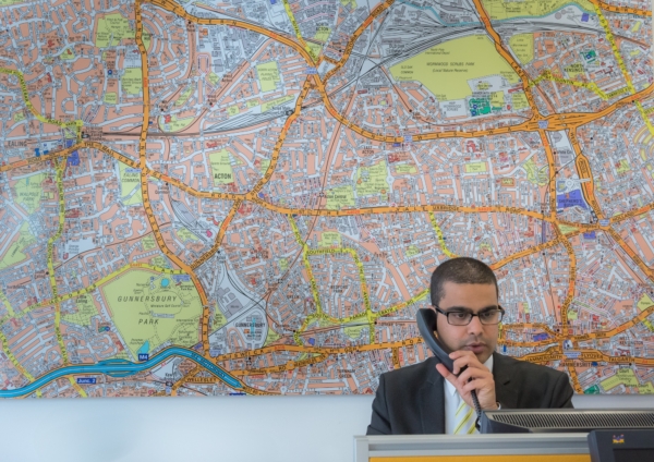 Image of man in office talking on phone with map in background