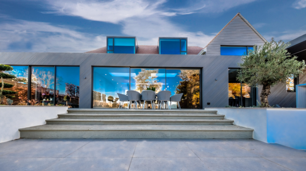 Luxury home with glass windows showing stunning refections just before dusk.